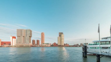 Panorama, Nieuwe Maas River bankasından Wilhelminapier ve Kop van Zuid 'e kadar olan zaman çizelgesini gösteriyor. Modern gökdelenler, feribot istasyonu ve Erasmus Köprüsü, kıyıdan geçen tekneler.