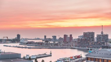 Rotterdam, Hollanda 'daki Katendrecht Yarımadası ve Maashaven Limanı' nın panoramik hava ve gece geçiş zamanı. Şehir silueti modern gökdelenler ve geleneksel Hollanda rıhtım evleri