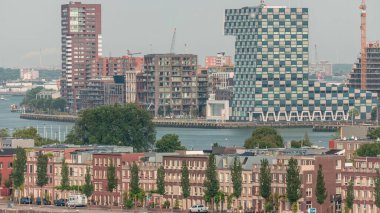 Rotterdam, Hollanda 'daki Katendrecht Yarımadası ve Maashaven Limanı' nın panoramik zaman çizelgesi. Şehir sabahları gökdelenler, vinçler ve geleneksel Hollanda rıhtım evleri.