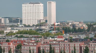 Rotterdam, Hollanda 'daki Katendrecht Yarımadası ve Maashaven Limanı' nın panoramik zaman çizelgesi. Şehir sabahları ufuk çizgisi, modern kuleler, inşaat alanı ve geleneksel sahil evleri