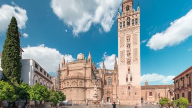 Seville Katedrali ve Giralda Kulesi Sevilla, İspanya 'da zaman atlaması. Dünyanın en büyük gotik katedrali olan UNESCO miras alanı Virgen de los Reyes Meydanı 'nda mavi gökyüzünün altında yer almaktadır.