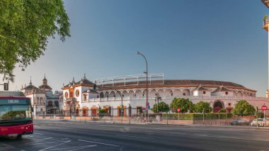 Plaza de Toros de la Real Maestranza de Caballeria de Sevilla zaman atlaması. İspanya 'nın Seville şehrinde boğa güreşi festivalleriyle tanınan tarihi boğa güreşi. Trafik ön cephesinin önünden geçiyor.