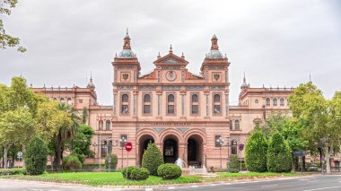 İspanya, Seville 'deki 2. Askeri Bölgenin Kaptanlığı cephesi. Endülüs 'teki Kara Kuvvetleri Karargahı. Trafik, bulutlu gökyüzü ve yeşil ağaçlarla hızlandırılmış zaman aşımı.