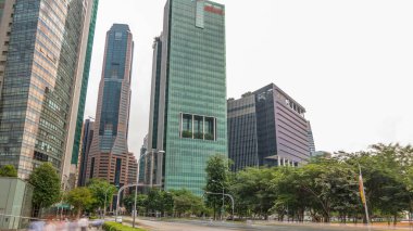 Skyline of Singapore city. Downtown skyscrapers office buildings of modern megalopolis timelapse hyperlapse. Traffic on a road. Reflections in glass surface and clouds on the sky.