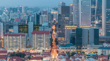 Çin Mahallesi 'ndeki ve Singapur' un merkezindeki yol trafiğinin hava görüntüsü çatıdan gece geçişi zamanı. Modern kuleler ve gökdelenler akşam aydınlandı.