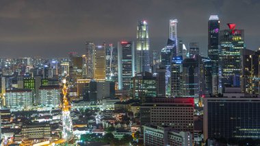 Çin Mahallesi ve Singapur Şehir Merkezi 'nin çatıdan gece geçiş zamanlarını gösteren hava manzarası. Yol trafiğiyle aydınlanan modern kuleler ve gökdelenler