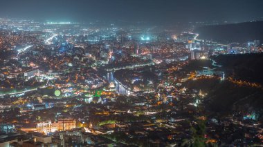 Rike Park 'ın olduğu şehir panoraması gece yukarıdan. Tiflis 'in eski bir kasabasındaki modern şehir parkı. Tarihi ve modern binalarla aydınlatılmış Barış Köprüsü ve hava balonu. Georgia