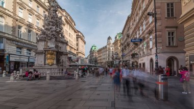 Graben Caddesi 'nde Viyana' nın ana caddesinde birçok dükkan ve restoran bulunan insanlar yürüyor. Pestsaule adındaki sütun, son büyük salgının sona ermesinden sonra açıldı.
