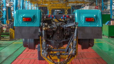 Konveyör montajı, traktörün gövdesini büyük endüstriyel fabrika zaman diliminde sahneleyecek. Çerçeve montajı, arka ışık kurulumu ve diğer bölümler.