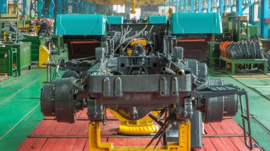 Konveyör montajı, traktörün gövdesini büyük endüstriyel fabrika zaman diliminde sahneleyecek. Çerçeve montajı, borular ve kablolarla kurulum parçaları