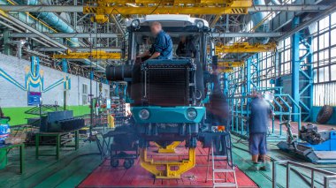 Konveyör montajı, traktörün gövdesini büyük endüstriyel fabrika zaman diliminde sahneleyecek. Çerçeve montajı, motor, egzoz borusu ve tekerlek kurulumu ve diğer bölümler.