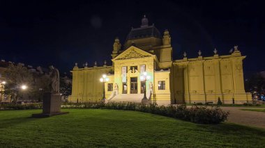 Zagrep 'teki sanat pavilyonu gece saatlerinde aşırı hızlanarak aydınlandı. Hırvatistan. Bahçedeki ön cephede anıt