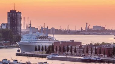 Hollanda 'nın Rotterdam şehrinde gün batımında Maashaven Limanı' nın hava zamanı. Rıhtımın ufuk çizgisi ve eski bir yolcu gemisi olan SS Rotterdam, şimdi Katendrecht 'e demirlemiş bir otel.