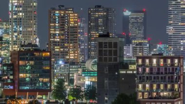 Rotterdam şehir merkezi, Hollanda 'daki modern binaların uçuş zamanı. Finans bölgesinde aydınlık kuleler ve gökdelenler. Parlayan pencereler, parlak bir gece silueti oluşturuyor.