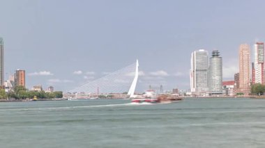 Hollanda, Rotterdam 'daki Maas Nehri' ni kapsayan Kuğu adlı Erasmus Köprüsü zaman çizelgesi panoraması. Hollands 'ın en büyük kablo destekli basküle köprüsü gökdelenleri, tekneleri ve bulutlu mavi gökyüzü