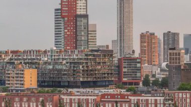 Rotterdam, Hollanda 'daki Katendrecht yarımadasının ve Maashaven limanının uçuş zamanı. Sabahları sıcak ışık, modern gökdelenler ve geleneksel Hollanda rıhtım evleri ile şehir silueti yükseliyor.