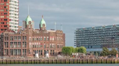 Rotterdam şehir merkezindeki Hotel New York tarihi cepheli modern binaların zaman çizelgesi. Eski Hollanda-Amerika Hat Karargahı. Tekneler geçerken insanlar rıhtımda dinleniyor. Simgesel mimari