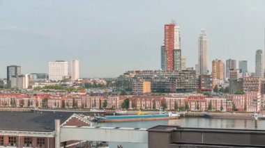 Rotterdam, Hollanda 'daki Katendrecht Yarımadası ve Maashaven Limanı' nın panoramik zaman çizelgesi. Sabah şehir silueti, modern gökdelenler ve Hollanda kıyısı evleri olan eski fabrikalar.