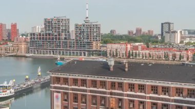 Rotterdam 'daki Maashaven' da, iç kısımlara demirlemiş gemiler, Katendrecht ve Maas Nehri 'nin üzerindeki hava zaman ayarlı görüntüsü. Eski fabrika ofis ve etkinlik alanına dönüştü. Hollanda