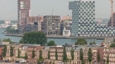 Rotterdam, Hollanda 'daki Katendrecht Yarımadası ve Maashaven Limanı' nın panoramik zaman çizelgesi. Şehir sabahları gökdelenler, vinçler ve geleneksel Hollanda rıhtım evleri.