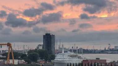 Maashaven Limanı 'nın hava zamanı, Hollanda Rotterdam' da günbatımında turuncu bulutlar. Rıhtım manzarası ve eski yolcu gemisi SS Rotterdam, şimdi Katendrecht 'e demirlemiş bir otel.