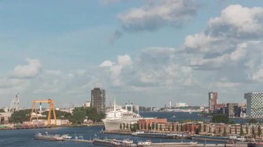 Arka planda Katendrecht ve Maas Nehri 'nin yer aldığı Maashaven' ın havadan görüntüsü. Sıcak sabah ışığıyla gökdelenlerin üzerinde dramatik bulutlu bir gökyüzü. Arkaplanda kargo portu