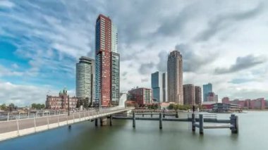 Hollanda, Rotterdam 'da bulunan ve yerel olarak Hoerenloper olarak bilinen Rijnhaven Köprüsü' nden Hiperlapse. Arka planda modern gökdelenleri ve bulutlu gökyüzü olan bir yaya ve bisiklet köprüsü