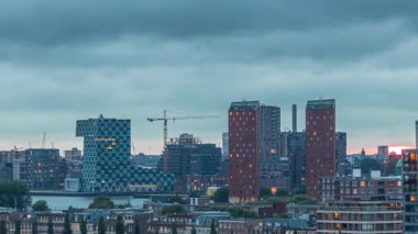 Rotterdam, Hollanda 'daki Katendrecht Yarımadası ve Maashaven Limanı' nın panoramik hava ve gece geçiş zamanı. Şehir silueti modern gökdelenler ve geleneksel Hollanda rıhtım evleri