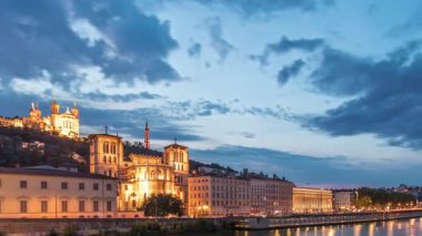 Aziz John 'un Vaftizci Katedrali ve Lyon' daki Notre-Dame de Fourviere Bazilikası 'nın zaman çizelgesi, günden geceye değişiyor. Yansıtılmış rıhtım ve nehirde yansıyan binalar. Fransa