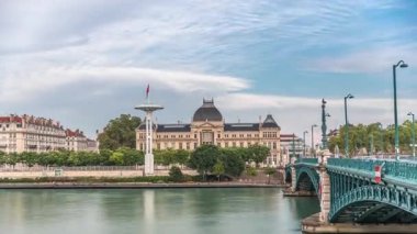 Fransa 'nın Lyon kentindeki Jean-Moulin Üniversitesi' nin yer aldığı Rhone Nehri 'nin panoramik hiperhızlandırılmış manzarası ve seti. Parçalı bulutlu bir gökyüzü zaman diliminin altında Üniversite Köprüsü ve rıhtımını içerir
