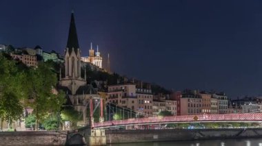 Aziz George Kilisesi, Quais de Saone ve Fourviere Bazilikası 'nın Fransa' nın Vieux Lyon kentindeki bir yaya köprüsünden hızlandırılmış zaman aşımına uğraması, geceleri tarihi mimari, yansımalar ve manzaralı nehir manzarası sergilenmektedir.
