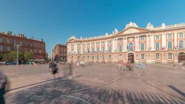 Capitole de Toulouse zaman çizelgesini gösteren panorama, Fransa 'nın Toulouse şehrinin tarihi belediye binası ve belediye kalbini, Capitole Meydanı' nda, çarpıcı mavi bulutlu gökyüzünün altında sergiliyor.