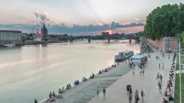 Fransa 'nın Toulouse kentindeki Garonne Nehri boyunca uzanan Port de la Daurade parkının hava görüntüsü. Gün batımında Saint-Pierre Köprüsü 'ndeki La Grave Hastanesi' nde renkli bulutlar...