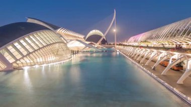 Valencias Sanat ve Bilim Şehri 'nin panoramik günden geceye geçiş zamanı ve fütüristik mimari üzerine dolunay dingin suya yansıyor. Büyüleyici bir İspanyol kültürel simgesi