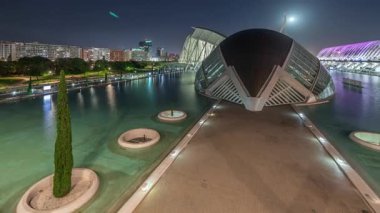 Valencias Sanat ve Bilim Şehri 'nin fütüristik mimarisi üzerinde dolunay varken serin sulara yansıyan çarpıcı zaman çizelgesini gösteren panorama. Büyüleyici bir İspanyol kültürel simgesi