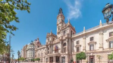 Valencia Belediye Binası Ajuntament de Valencia zaman atlaması Plaza de Ayuntamiento 'da. Mavi gökyüzünün altında saat kulesi olan tarihi bir bina. İspanya 'nın ana meydanında gezinen insanlar