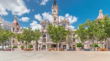 Valencia Belediye Binası Ajuntament de Valencia zaman atlaması Plaza de Ayuntamiento 'da. Mavi bulutlu gökyüzünün altında saat kulesi olan tarihi bir bina. İspanya 'nın ana meydanında gezinen insanlar