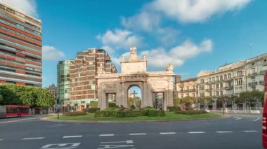 İspanya, Valencia 'da La Porta de la Mar zaman atlaması. Bir zamanlar ortaçağ duvarlarının bir parçası olan bu neoklasik kapı kalabalık bir kavşağın üzerinde duruyor. Gün batımında parlak bir gökyüzünün altında değerli bir şehir simgesi.