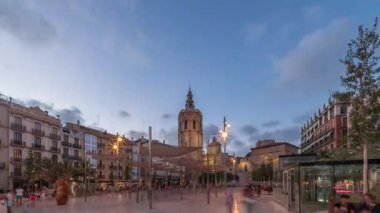 İspanya, Valencia 'daki Plaza de la Reina' da panoramik günden geceye geçiş süreleri aşırı hızlanıyor. Tarihi bir kilise kulesi, hareketli kafeleri ve akşam gökyüzünün altında merkezi bir çeşmesi olan canlı bir meydan..