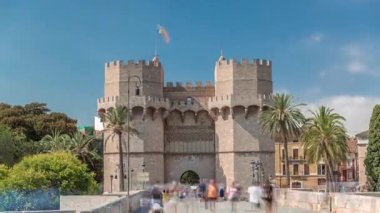 Serrans Kuleleri Torres de Serranos zaman atlaması. Valencia, İspanya 'da. Şehrin antik duvarlarından gelen büyük bir ortaçağ kapısı. Mavi gökyüzü altındaki hareketli sokak manzaraları bu tarihi yeri çerçeveler.