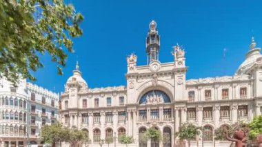 Panorama, Valensiya 'daki tarihi Postane Palau de les Comunicacions' ı gösteriyor. Şehir Meydanı Plaza del Ayuntamiento 'da. Süslü cephe, trafik ve İspanya şehir merkezinde mavi bir gökyüzü..