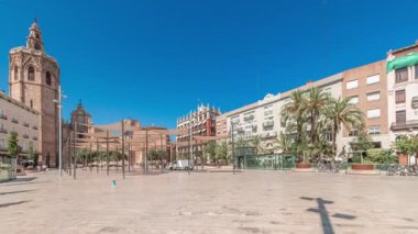 Panorama, İspanya, Valencia 'daki Plaza de la Reina' nın zaman çizelgesini gösteriyor. Tarihi bir kilise kulesi, hareketli kafeler ve sıcak Akdeniz mavi gökyüzünün altında merkezi bir çeşmesi olan canlı bir meydan..