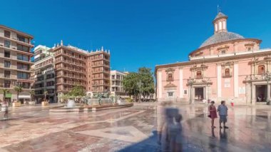 Valencias Plaza de la Virgen 'in zaman çizelgesini gösteren panorama, Katedral, Basilica de la Virgen de los Desamparados ve Turia Fountain' in mavi gökyüzü altında sergileniyor.