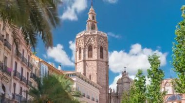 Valencia, İspanya 'daki Plaza de la Reina' nın panoramik zaman çizelgesi. Tarihi bir kilise kulesi, hareketli kafeler ve sıcak Akdeniz bulutlu gökyüzünün altında merkezi bir çeşme..