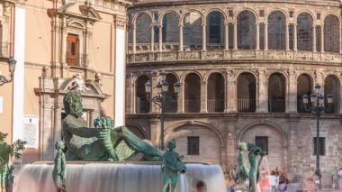 Valencia, İspanya 'daki ikonik Turia Pınarı ile birlikte Plaza de la Virgen' den Timelapse. Neptün heykeli Turia Nehri ve kanallarını temsil eder. Meydanda yürüyen gölgelerle gezen insanlar