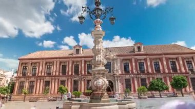 Sevilla Başpiskoposu ve Fuente Farola çeşmesi Plaza de Virgen de los Reyes şehir meydanı hiperhızlandırılmış zaman aralığı. Tarihi mimarisi olan mavi bulutlu bir gökyüzü. Sevilla, Endülüs, İspanya.