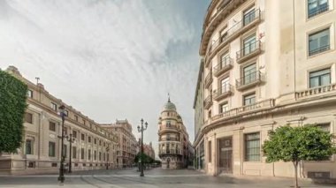 Avda boyunca yürüyen yayalar. De la Constitucion, Seville, İspanya 'nın Casco Antiguo bölgesindeki ana cadde. Edificio de la Adriatica ile zaman atlaması, tarihi binalar ve geçen tramvaylar