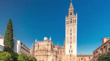 Seville Katedrali ve Giralda Kulesi 'nin Sevilla, İspanya' daki aşırı hızını gösteren panorama. Dünyanın en büyük gotik katedrali Virgen de los Reyes meydanında, mavi gökyüzünün altında.