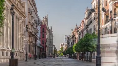 Avda boyunca yürüyen yayalar. De la Constitucion, Seville, İspanya 'nın Casco Antiguo bölgesindeki ana cadde. Edificio de la Adriatica yakınlarındaki zaman dilimi, tarihi binalar ve geçen tramvaylar