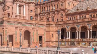 Seville Timelapse 'deki Plaza de Espana, Ibero-American Exposition için inşa edilen Maria Luisa Park' taki büyük bir mimari kompleks. Mavi bulutlu gökyüzünün altında kemerler, kanallar ve kırmızı duvarlar.